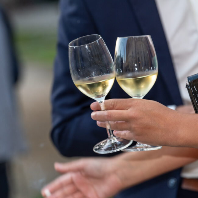 Photo de 2 verres de vin blanc frais en main