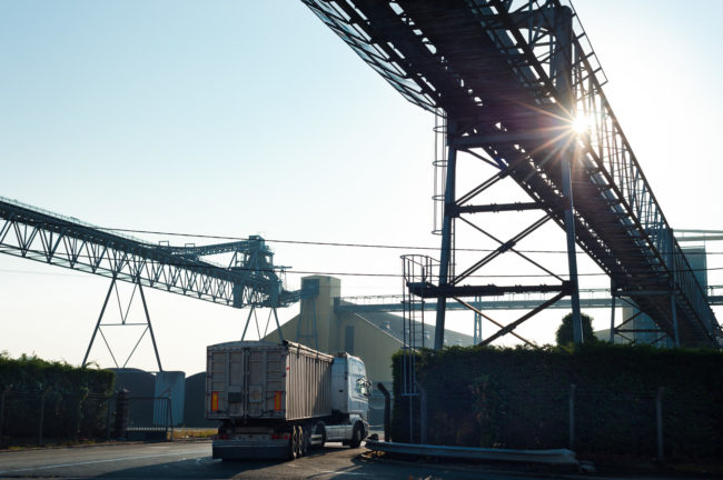Photographie en contrejour d'un camion entrant dans une entreprise de stockage céréalier
